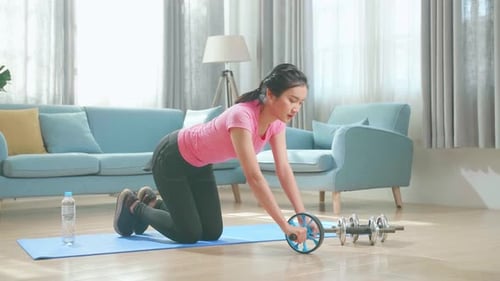 Woman Working Out Using Ab Roller in Living Room