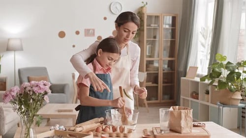 Mother and Daughter Baking Together in Cozy Kitchen
