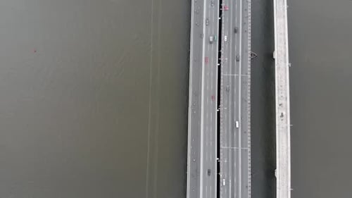 Aerial Drone Flight Overhead View of the City Bridge with Cars and Motorcycles Against the Backdrop