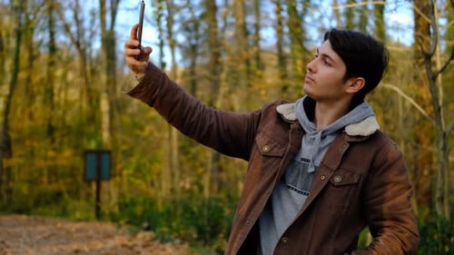 Young Adult Taking Photos in Forest with Phone