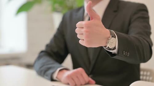 Nahaufnahme der Handgeste eines Mannes mittleren Alters mit Daumen hoch Schild