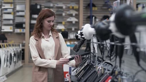 Retail Store, Pretty Female Shopper Choosing Hair Tools on Store Shelves During a Sale