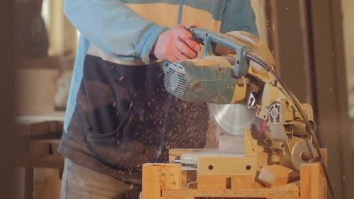 Woodworker Using Powered Miter Saw in Workshop
