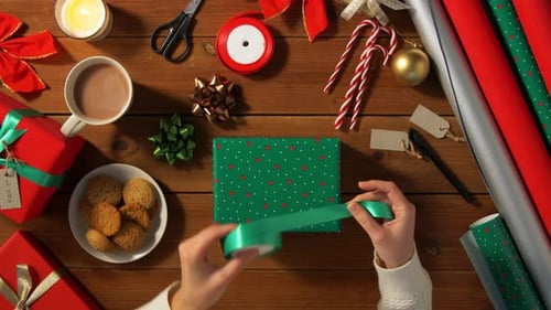 Hands Packing Christmas Gift and Choosing Bow