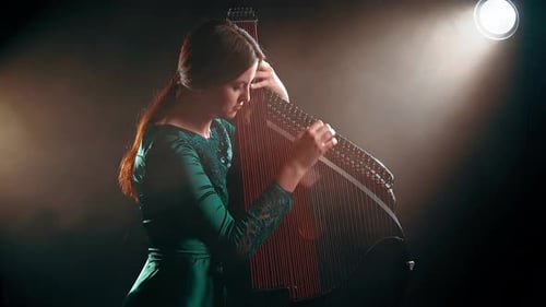 Woman Playing Traditional Stringed Instrument in Dark Studio