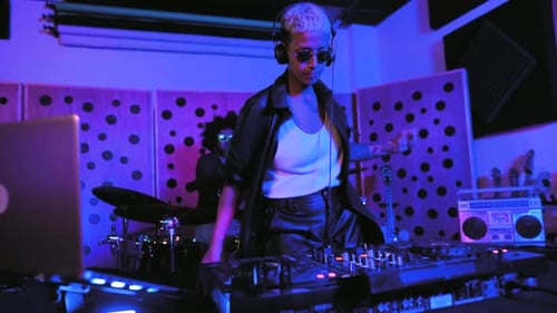 Young happy people playing music with dj mixer and drum in house studio