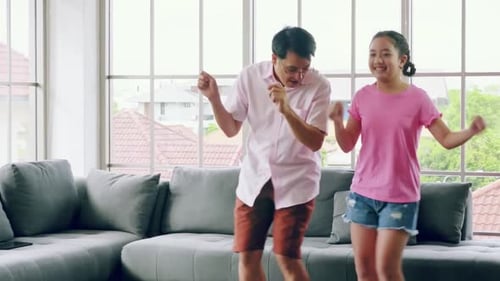 Happy Father and Teen Daughter Dancing Together Indoors