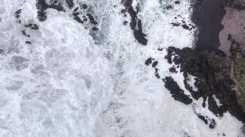 Ocean Waves Crashing on Rocky Shoreline from Above