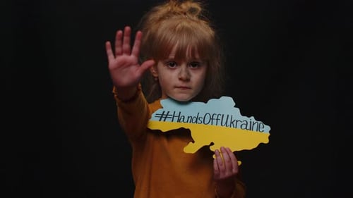 Portrait d'une petite fille ukrainienne avec texte d'inscription de massage sur la carte Hands Off Ukraine Crise guerre