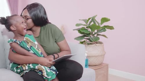 Mother and Child Using Tablet on Sofa