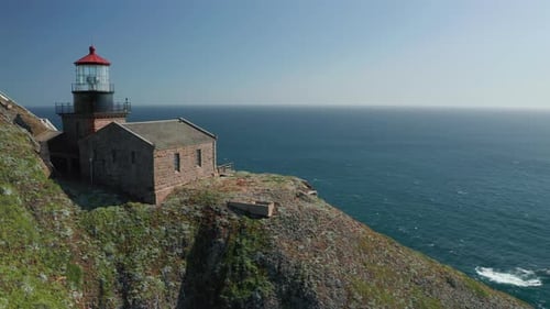 Cinematic Old Lighthouse with Red Roof on the Edge of the Sheer Cliff, Aerial