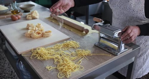 Woman working inside pasta factory while doing fresh italian tagliolini