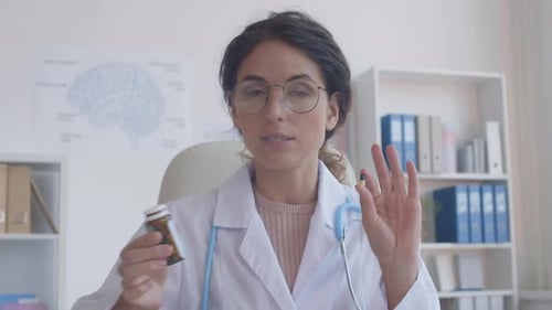 Woman Doctor Explaining Pills in Hospital Office