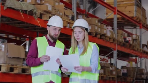 Warehouse Workers Reviewing Paperwork in a Workplace