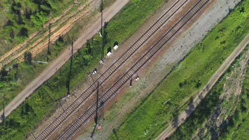 Elektrifizierte Eisenbahnstrecke. Die Kamera gewinnt beim Drehen an Höhe