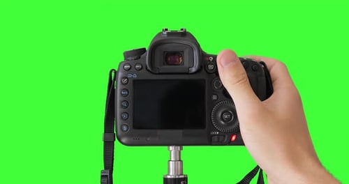 Man photographer is taking photos with professional digital camera. Keyed chroma key background.