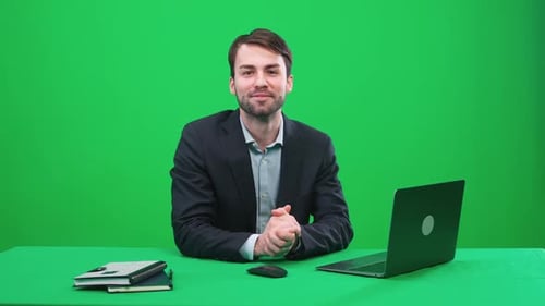 Man Reporter Sits in the Studio and Looks Into the Camera Speaks and Hosts a News Programon a Green