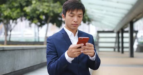 Young Businessman Using Smartphone Outdoors in City