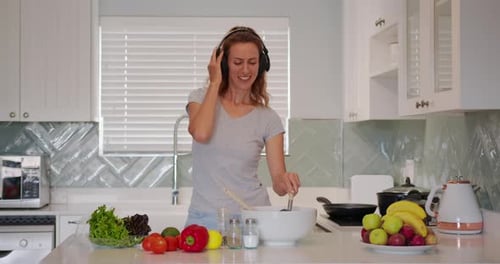 Happy Woman Cooking and Dancing in Kitchen