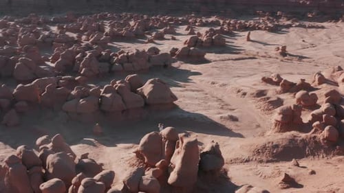 Drone is Flying Around Athletic Woman Walking with Backpack at Red Rocky Desert