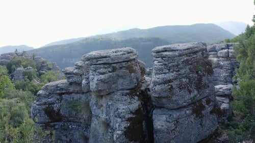Gray Rocky Formations on the Background of Sky and Mountains