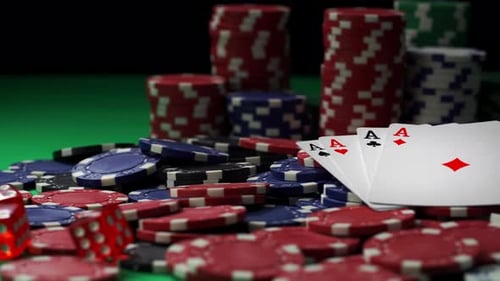 Red Dices and All Aces Lying on a Pile of Poker Chips on Green Table in Close-up