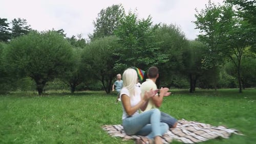 Family Day, Picnic in Nature, Boy and Girl Run Through a Clearing and Play with a Kite, Parents Sit