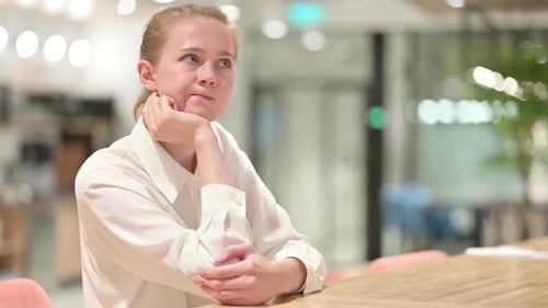 Woman Thinking in Brightly Lit Workplace