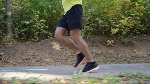 Legs of Male Runner on Park Road