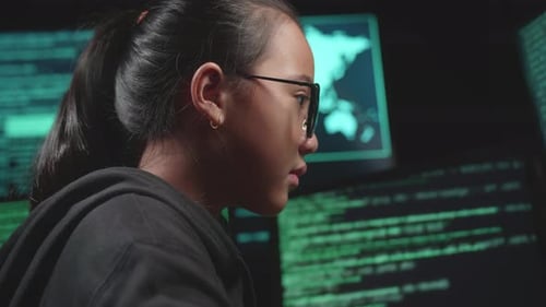 Asian Young Girl Hacker Hacking With Multiple Computer Screens In Dark Room