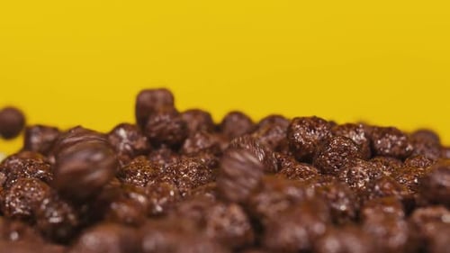 Chocolate Corn Cereal Balls Falling, Filling the Frame. Serving Breakfast. Close Up. Slow Motion