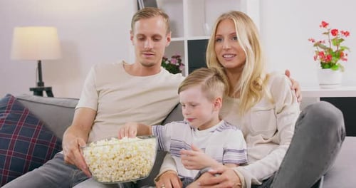 Loving Family Watching Movie with Popcorn at Home