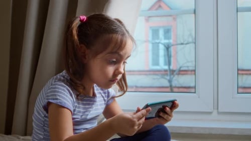 Girl Using Smartphone Device Indoors by Window