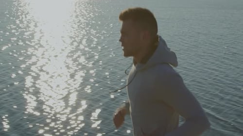 Strong Man Caucasian Is Running Near Lake