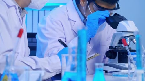 Scientists Working with Microscope in Medical Lab