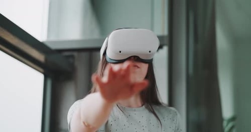Woman Using VR Headset Indoors, Interacting with Hand
