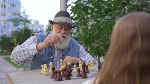 Zoom Out Älterer Großvater spielt Schach im Freien