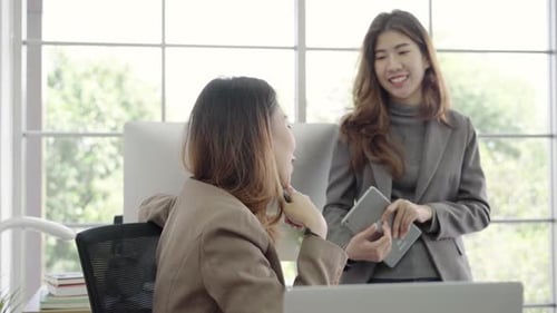 Businesswomen working on laptop and disscuss about work while working in office.