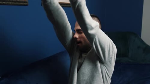 Young Man Relaxing on Blue Couch Indoors