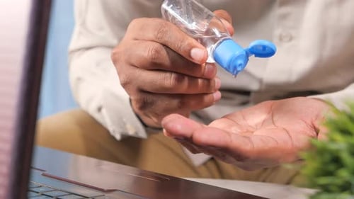 Applying Hand Sanitizer at Work Close Up