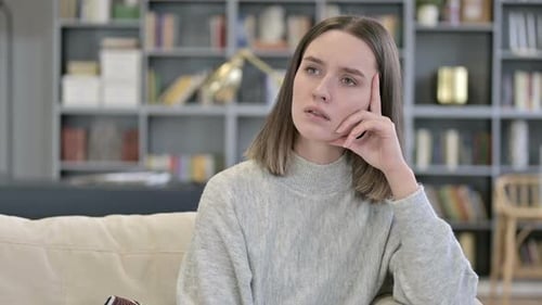 Thoughtful Woman Thinking on Couch Indoors