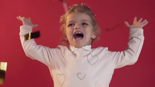 Lovely Exuberant Small Eirl with Attractive Smile Having Fun with Confetti
