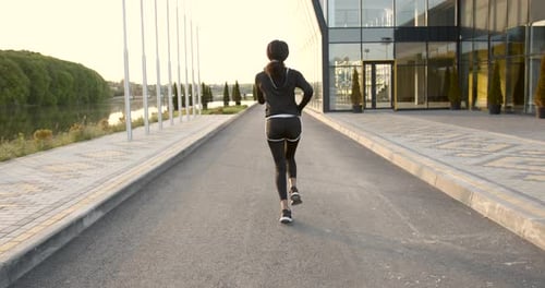 Woman Running for Fitness at Sunrise or Sunset