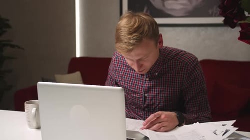 Young Man Working From Home At Desk