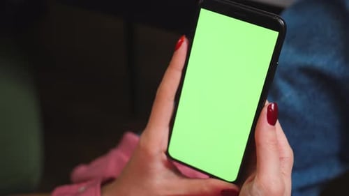Close Up Woman Hands Holding Chromakey Green Screen Smartphone Watching Content or Video at Home
