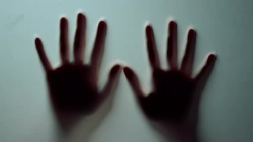 Macro Two Female Hands Pressing Against Glass Wall Indoors