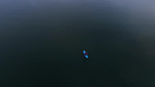 Kayakista flotando en el mar en calma. Vista aérea del hombre en kayak viajando en el mar