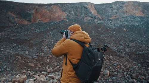 Man Photographs Rugged Landscape with Professional Camera