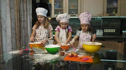 Drei Mädchen backen und spielen mit Mehl