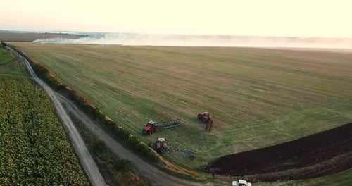 Tractors Ploughing a Large Field from Above